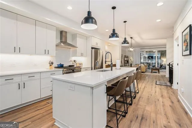 a kitchen with stainless steel appliances a table chairs refrigerator and cabinets