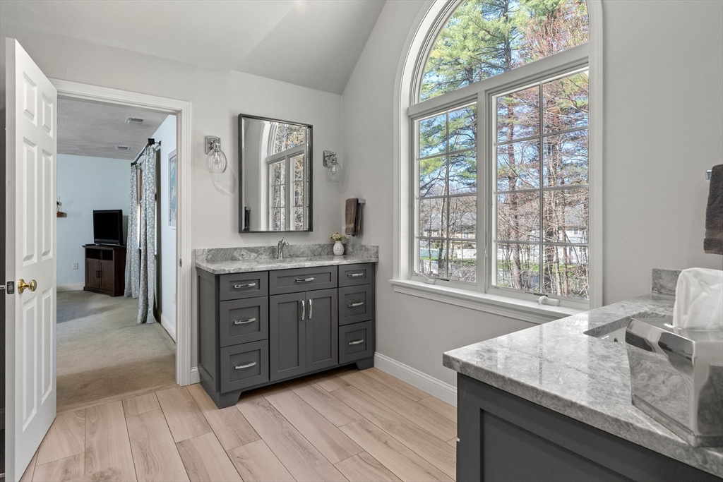 145 River Street Middleton, MA 01949 - Photo 23 of 42 a spacious bathroom with a granite countertop sink and a large mirror next to a window