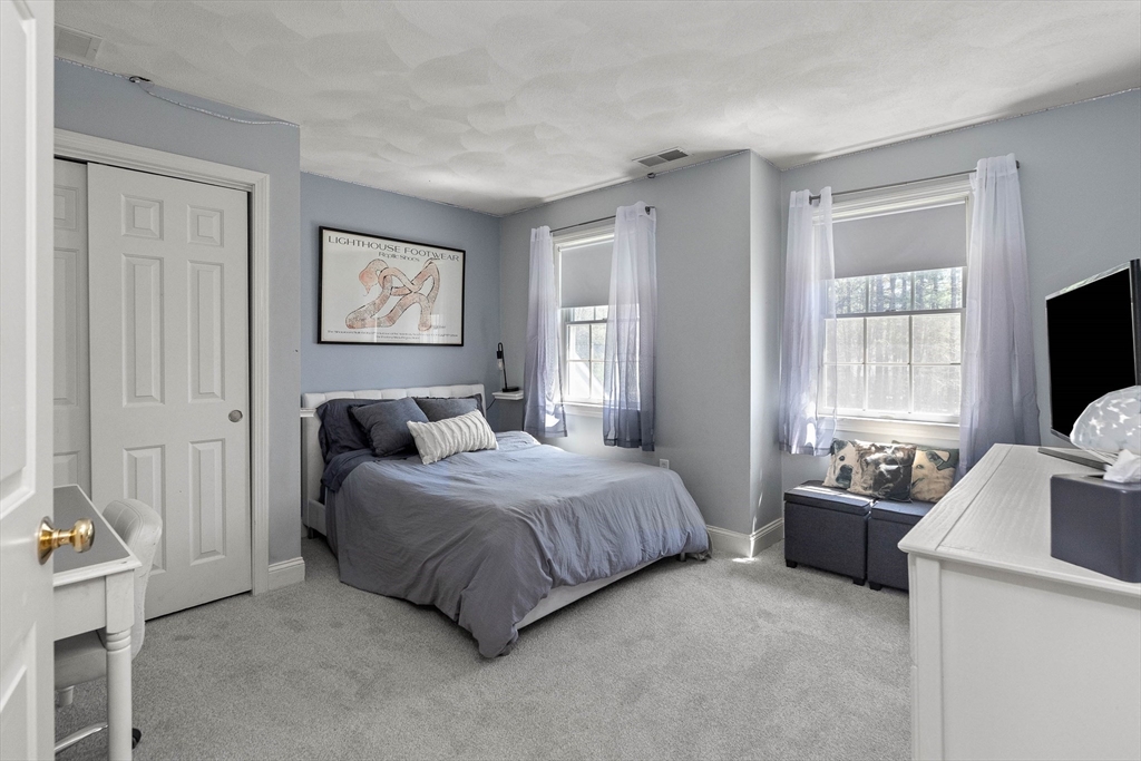 145 River Street Middleton, MA 01949 - Photo 25 of 42 a bedroom with a bed and a flat screen television