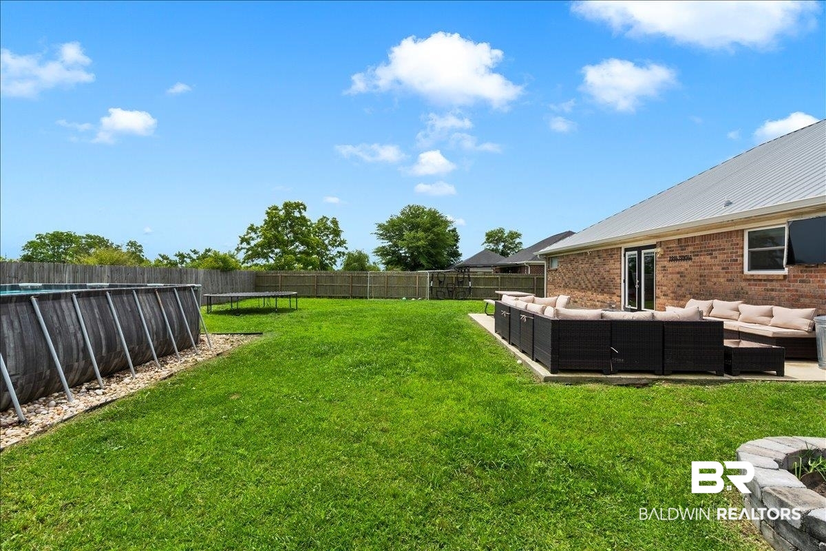 8952 Sherman Road Foley, AL 36535 - Photo 36 of 41 Expansive backyard featuring a lush lawn, privacy fencing, and a concrete patio