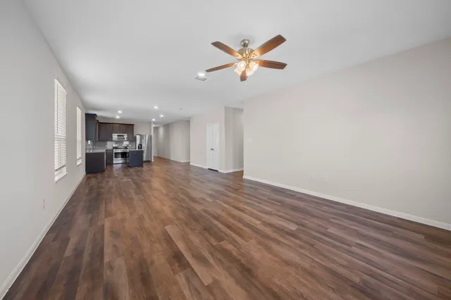 a view of empty room with wooden floor and window