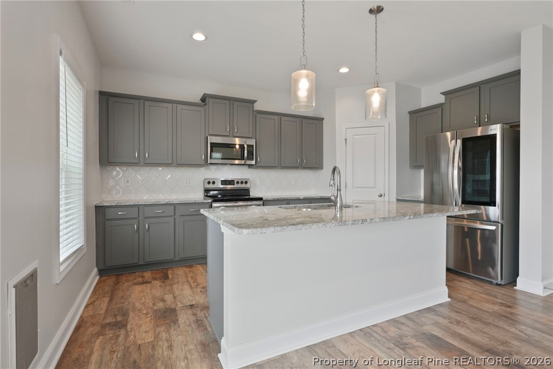 5150 J T Matthews Road Godwin, NC 28344 - Photo 19 of 50 a kitchen with stainless steel appliances granite countertop a sink a stove a refrigerator and a oven