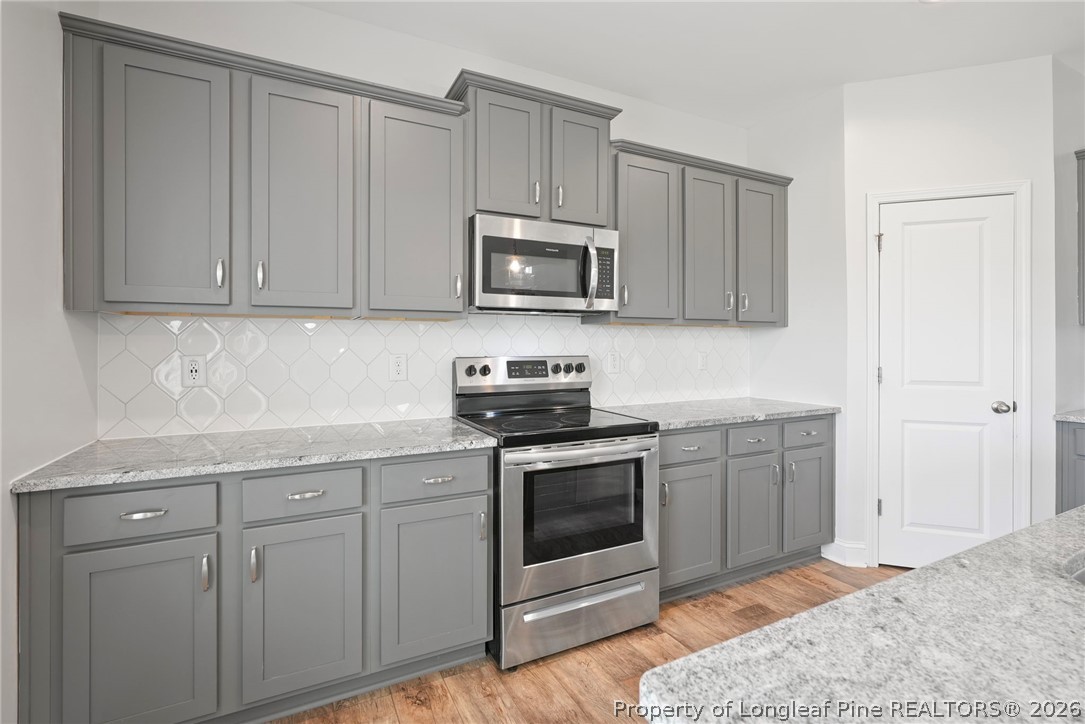 5150 J T Matthews Road Godwin, NC 28344 - Photo 20 of 50 a kitchen with white cabinets and stainless steel appliances