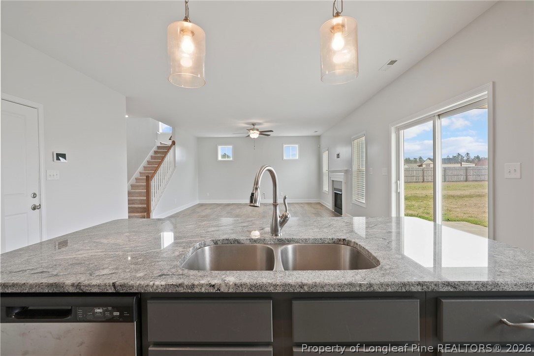 5150 J T Matthews Road Godwin, NC 28344 - Photo 22 of 50 a kitchen with kitchen island granite countertop a sink a counter top space and living room view