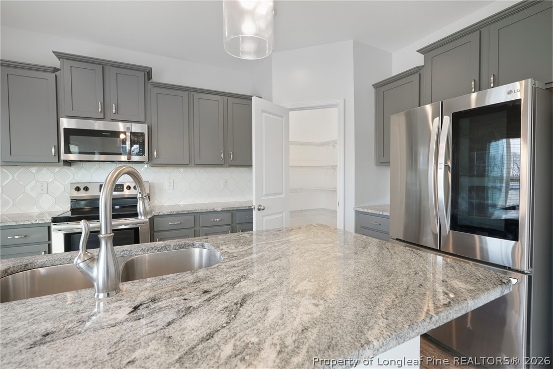 5150 J T Matthews Road Godwin, NC 28344 - Photo 23 of 50 a kitchen with stainless steel appliances granite countertop a stove a microwave and a refrigerator