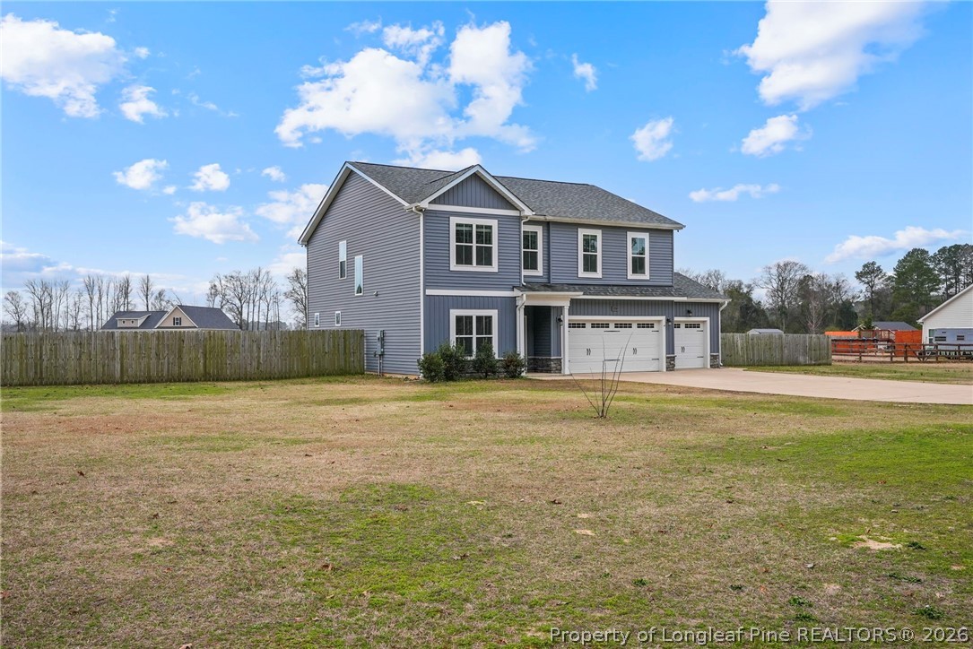 5150 J T Matthews Road Godwin, NC 28344 - Photo 4 of 50 a front view of a house with a yard and a garage