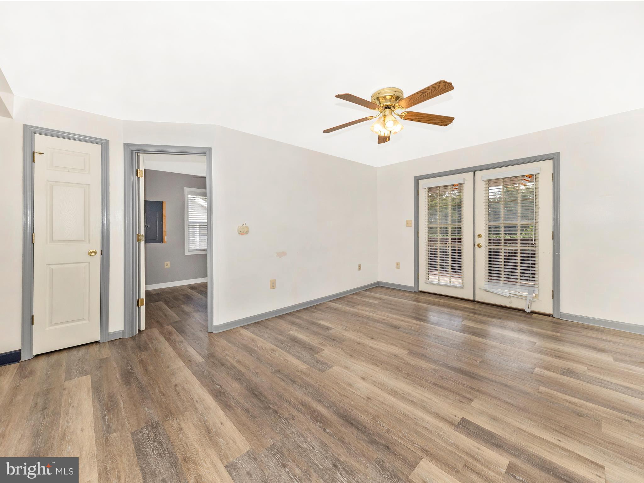 9320 Rocky Ridge Road Rocky Ridge, MD 21778 - Photo 9 of 54 an empty room with wooden floor ceiling fan and windows