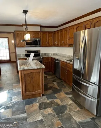 a kitchen with stainless steel appliances granite countertop a stove a sink and a refrigerator