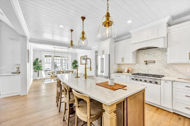 a kitchen with a table chairs stove and wooden floor