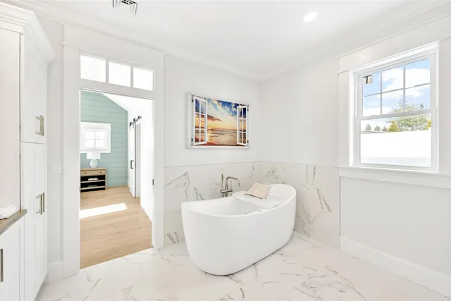 a spacious bathroom with a granite countertop sink mirror and a bathtub