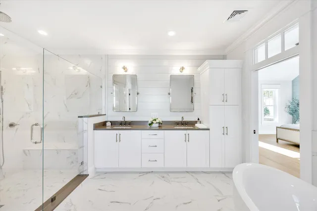 a bathroom with a double vanity sink mirror and shower