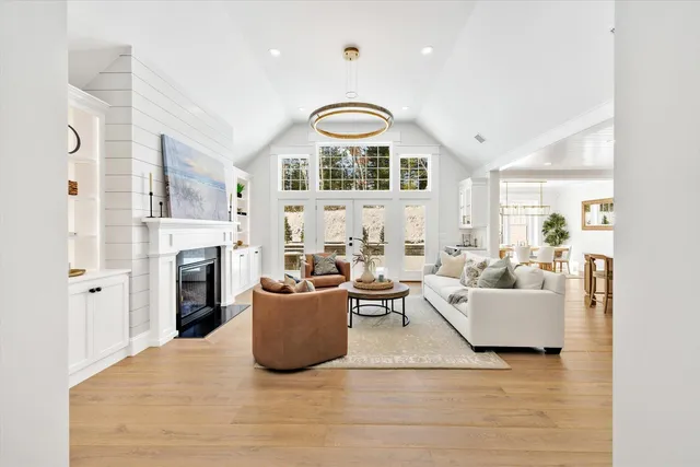 a living room with furniture a fireplace and a large window