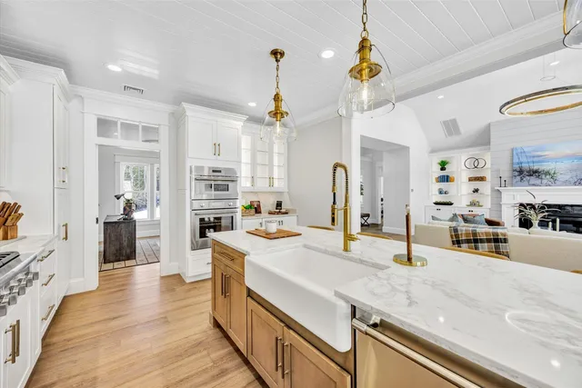 a large kitchen with kitchen island a refrigerator a stove a sink dishwasher and a dining table with wooden floor