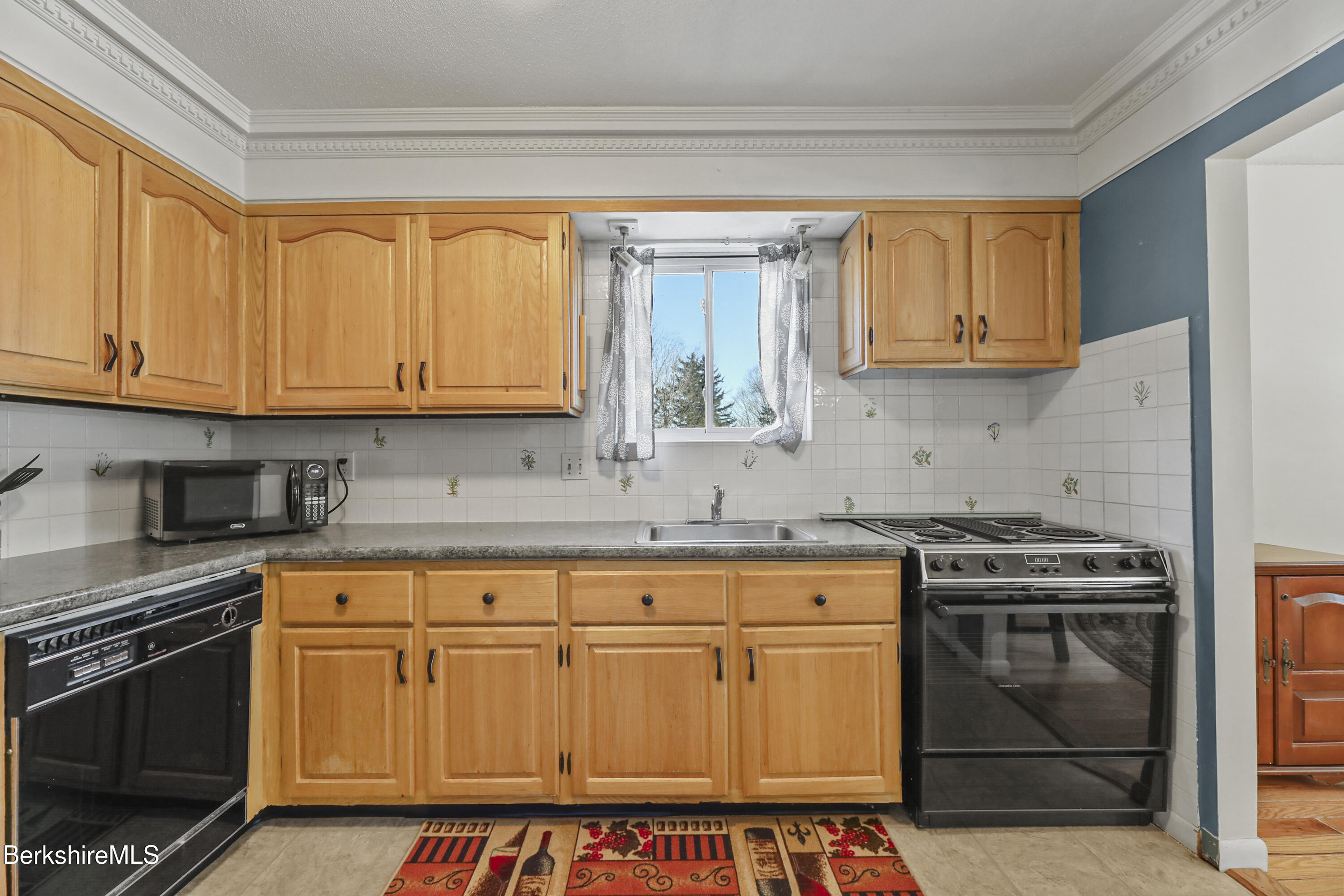 44 Churchill Crest, Unit 44 Pittsfield, MA 01201 - Photo 12 of 25 a kitchen with stainless steel appliances granite countertop a stove a sink and a microwave