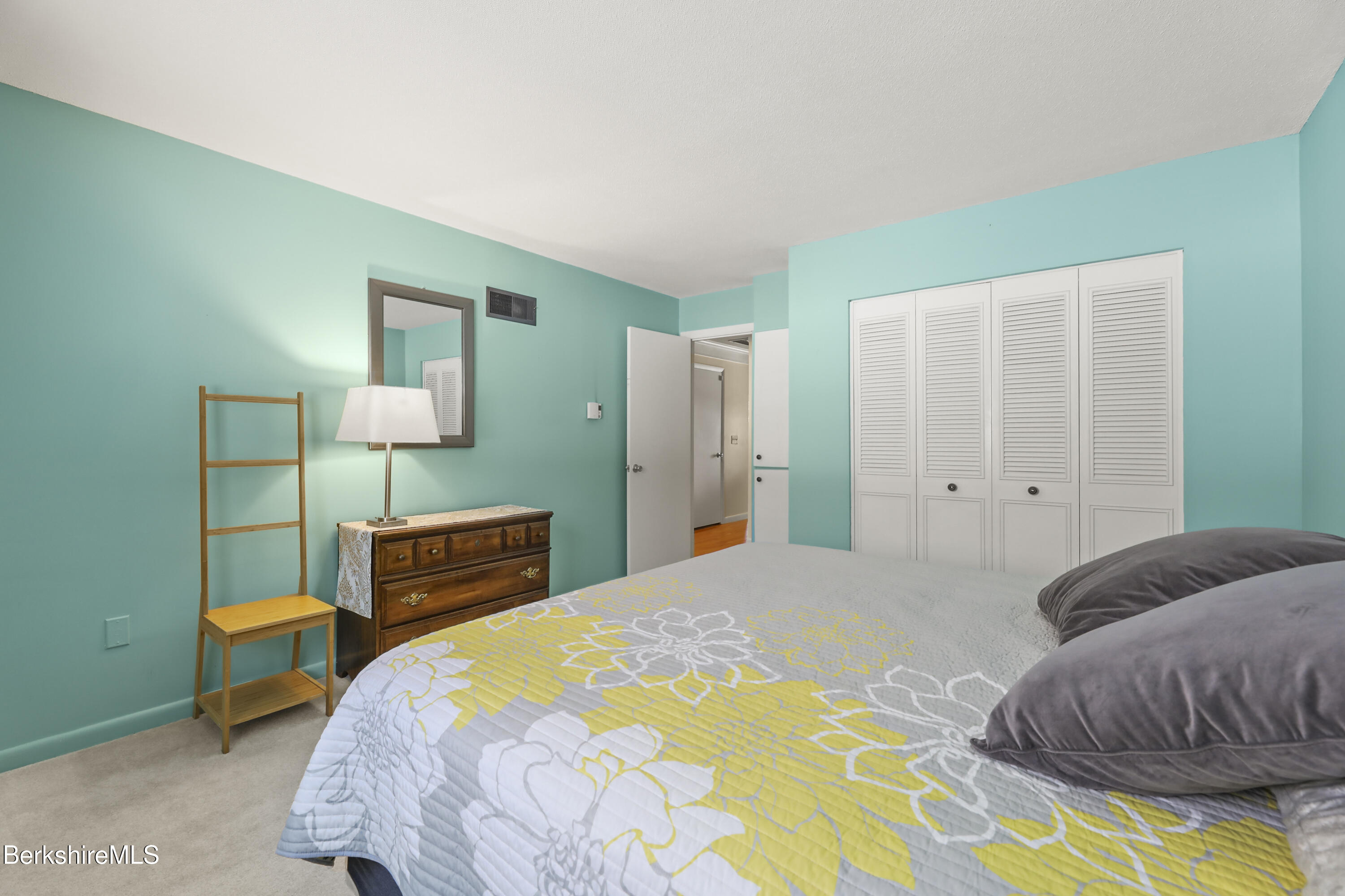 44 Churchill Crest, Unit 44 Pittsfield, MA 01201 - Photo 16 of 25 a bedroom with a bed a dresser and painting on the wall