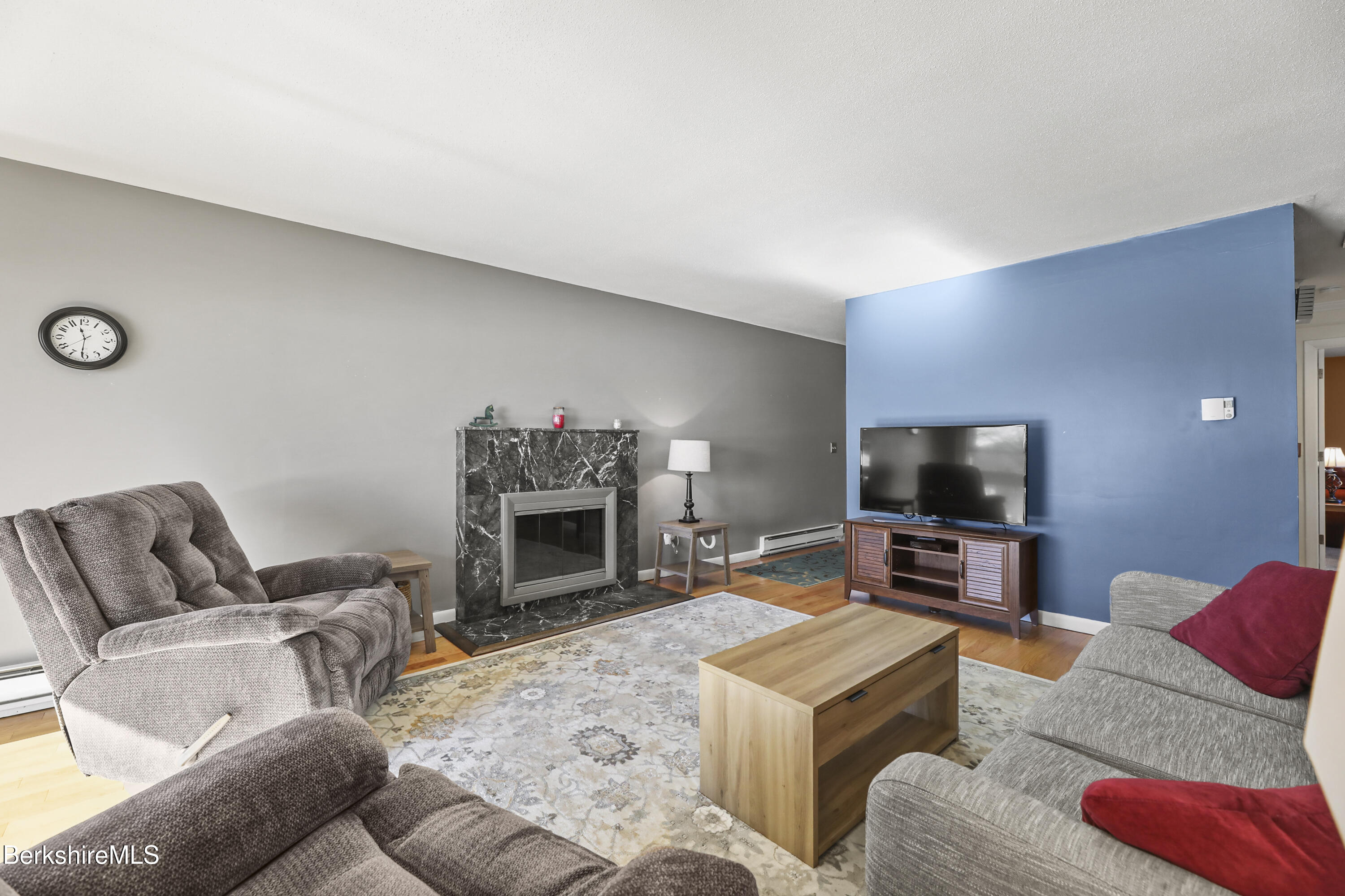 44 Churchill Crest, Unit 44 Pittsfield, MA 01201 - Photo 8 of 25 a living room with furniture a flat screen tv and a fireplace