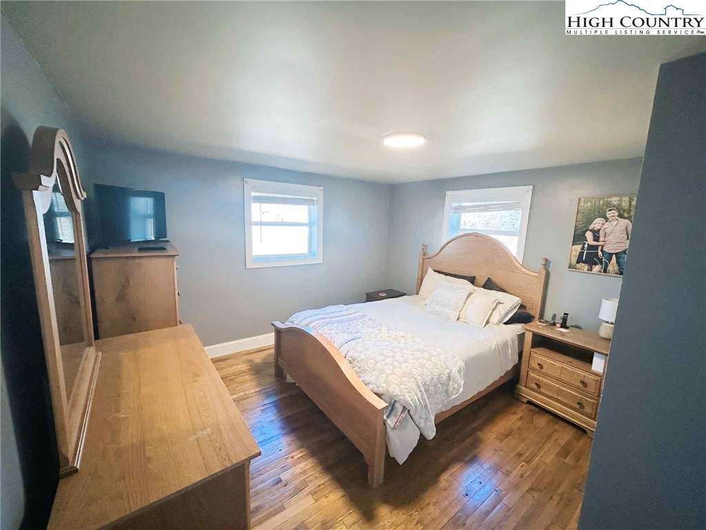 1145 Lazy Branch Road Ennice, NC 28623 - Photo 11 of 13 a bedroom with a bed lamp and a large window