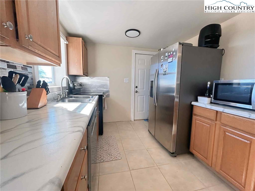 1145 Lazy Branch Road Ennice, NC 28623 - Photo 8 of 13 a kitchen with stainless steel appliances granite countertop a refrigerator and a sink