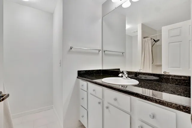a bathroom with a granite countertop sink and a mirror