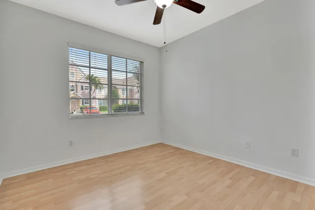 an empty room with a window and a ceiling fan
