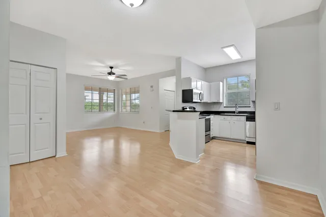 a view of a kitchen with kitchen island and stainless steel appliances