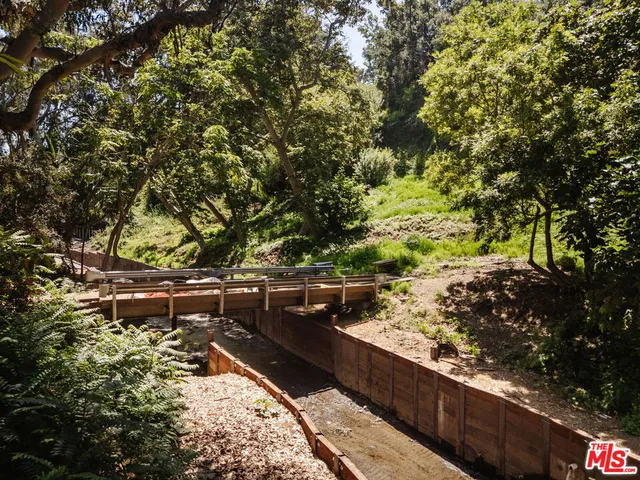 a yard with wooden fence and some trees