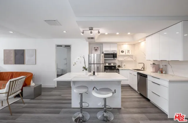 a kitchen with stainless steel appliances kitchen island granite countertop a sink and cabinets