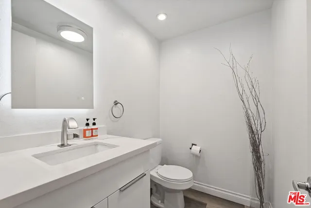 a bathroom with a sink toilet and a mirror