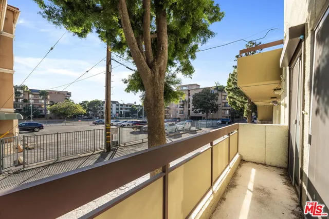 a view of a balcony with floor to ceiling windows and wooden fence