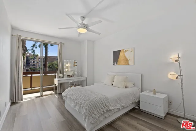 a spacious bedroom with a large bed and a chandelier