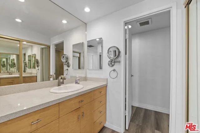 a bathroom with a double vanity sink mirror and shower