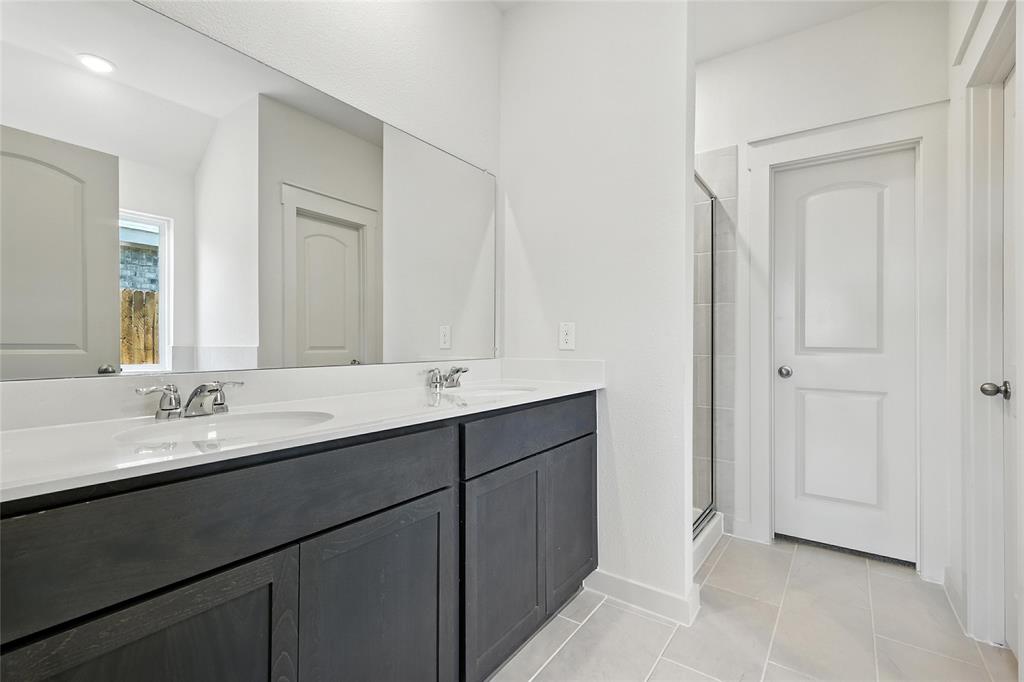 1795 Gleasondale Place Forney, TX 75126 - Photo 16 of 29 Full bath featuring double vanity, a shower stall, and light tile patterned floors
