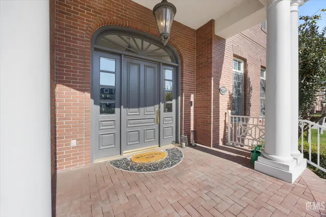 a living room with furniture a chandelier and kitchen view