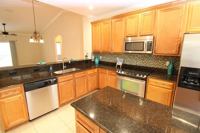 a kitchen with granite countertop a sink a stove and cabinets