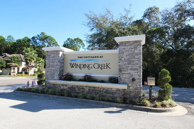 a front view of a house with a yard and potted plants