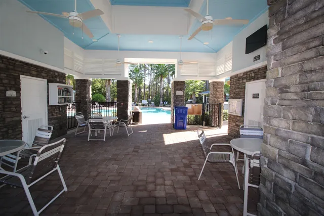 a view of a patio with a table and chairs under an umbrella with wooden fence