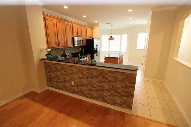 a kitchen with stainless steel appliances granite countertop a stove a sink and a refrigerator