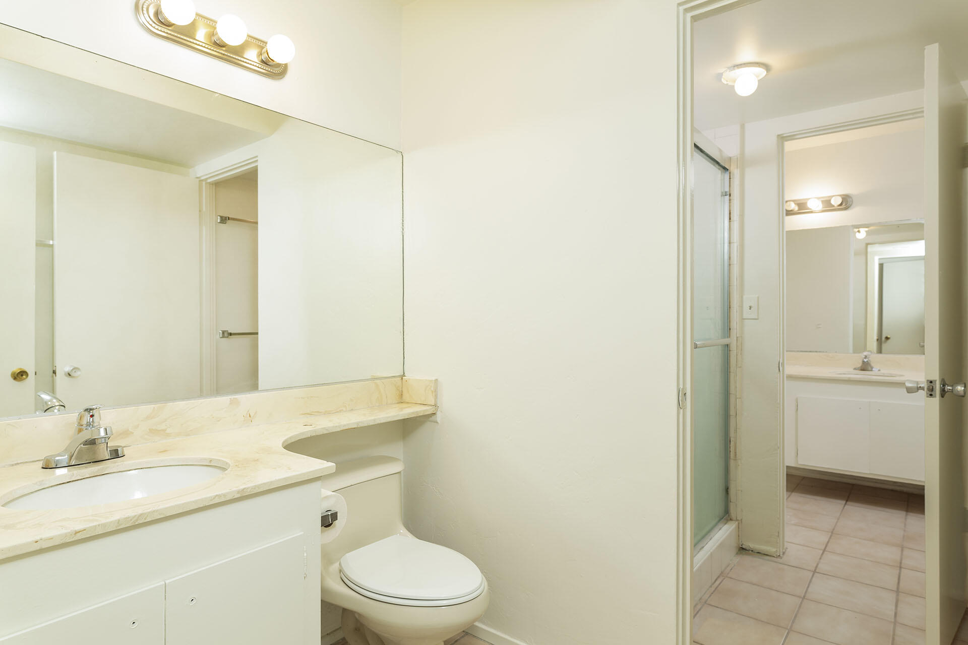 42336 Dunes View Road, Unit 12 Rancho Mirage, CA 92270 - Photo 22 of 29 a bathroom with a granite countertop sink toilet a large mirror a shower and a