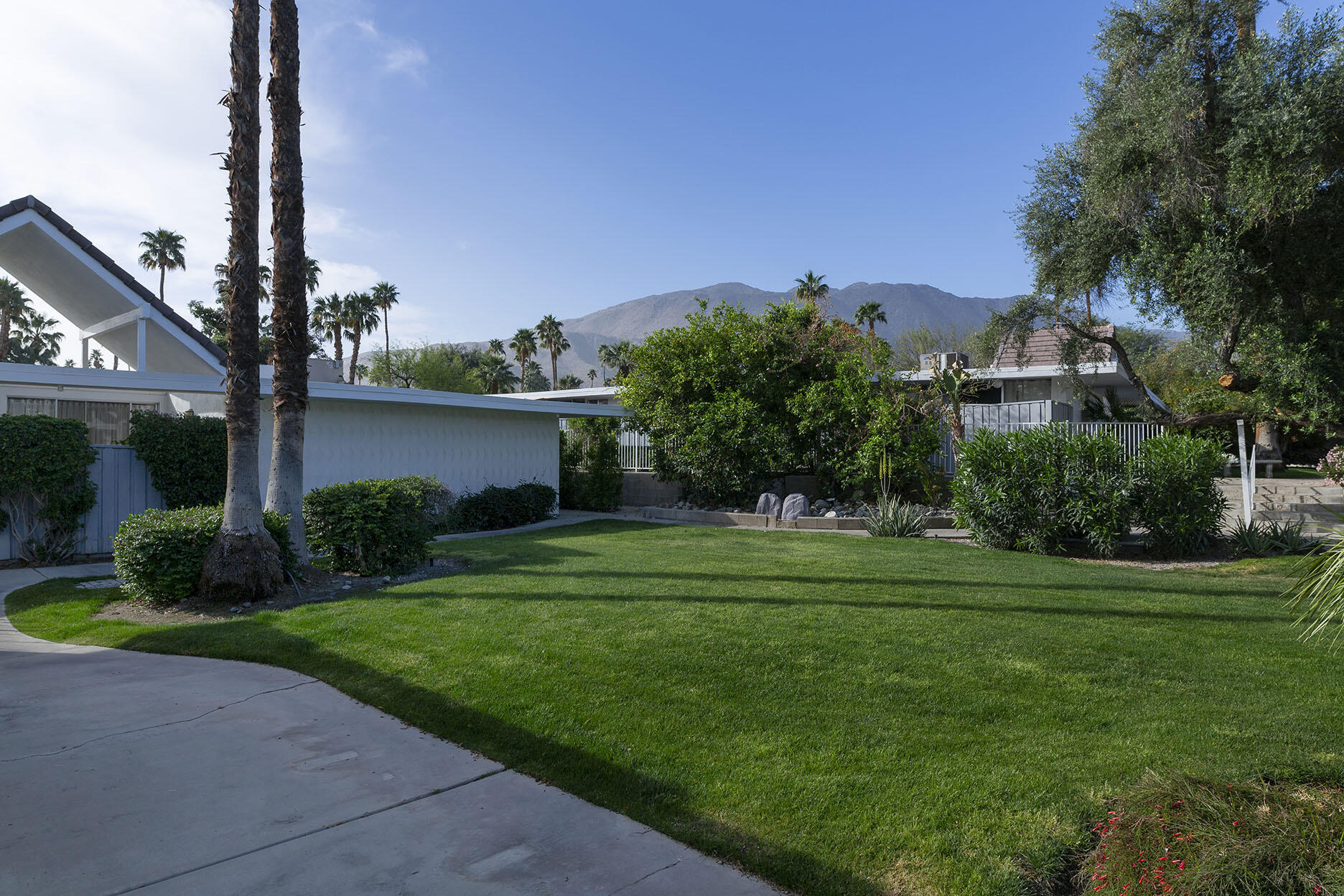 42336 Dunes View Road, Unit 12 Rancho Mirage, CA 92270 - Photo 29 of 29 a front view of a house with a yard and potted plants