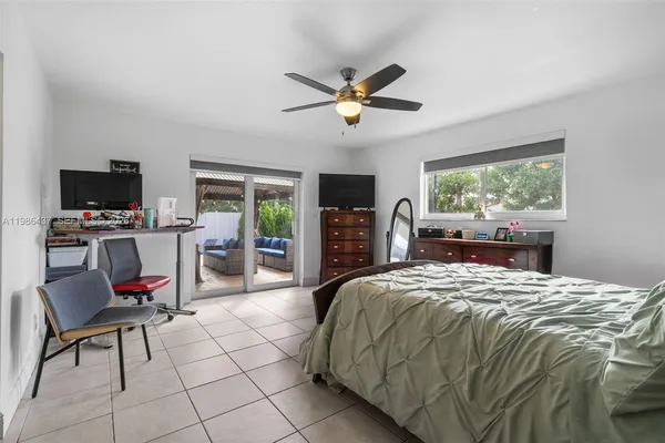 a bedroom with a bed a chandelier and flat screen tv