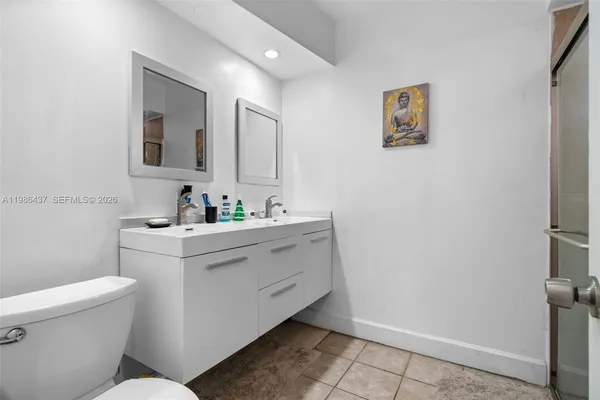 a bathroom with a sink mirror vanity and toilet