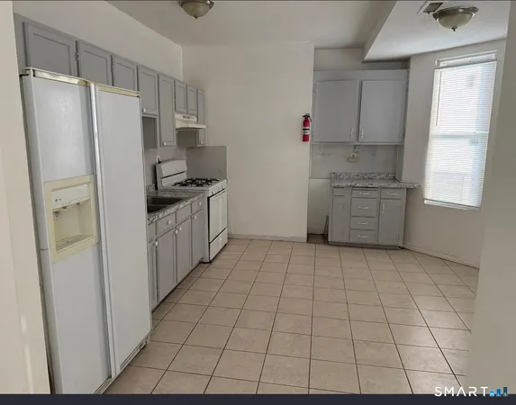 a kitchen with stainless steel appliances a refrigerator sink and cabinets