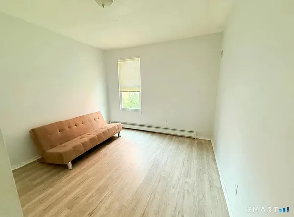 a view of a room with wooden floor and a window
