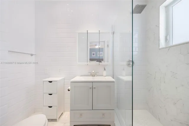 a bathroom with a sink a toilet and shower