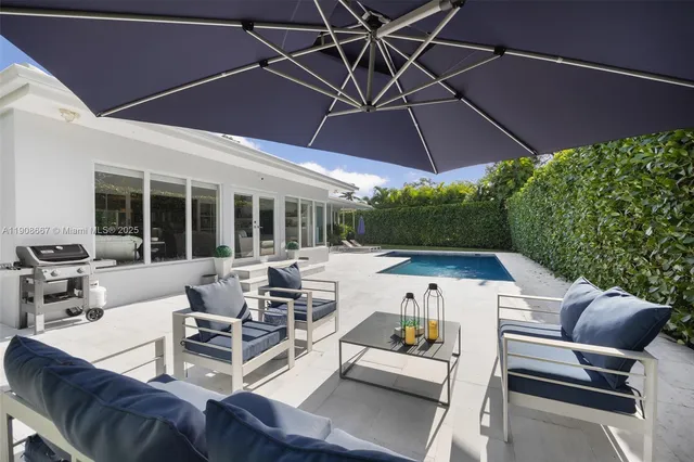 a view of a patio with table and chairs under an umbrella