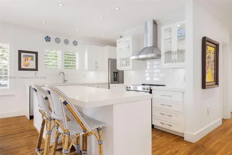 a kitchen with stainless steel appliances white cabinets and wooden floor
