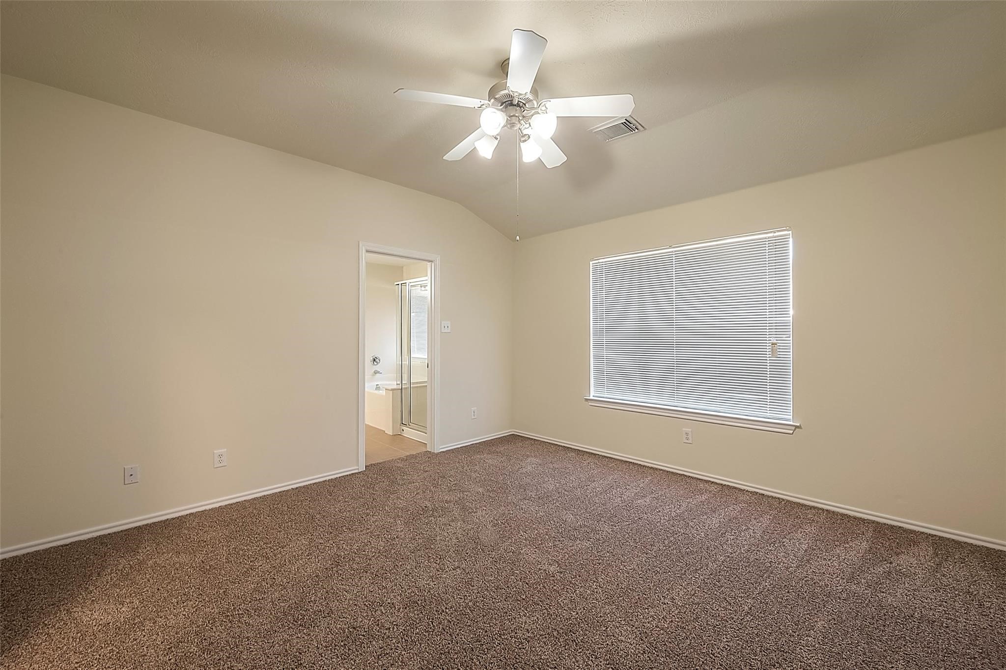 14330 Fairbuff Lane Houston, TX 77014 - Photo 22 of 35 an empty room with a chandelier fan and windows