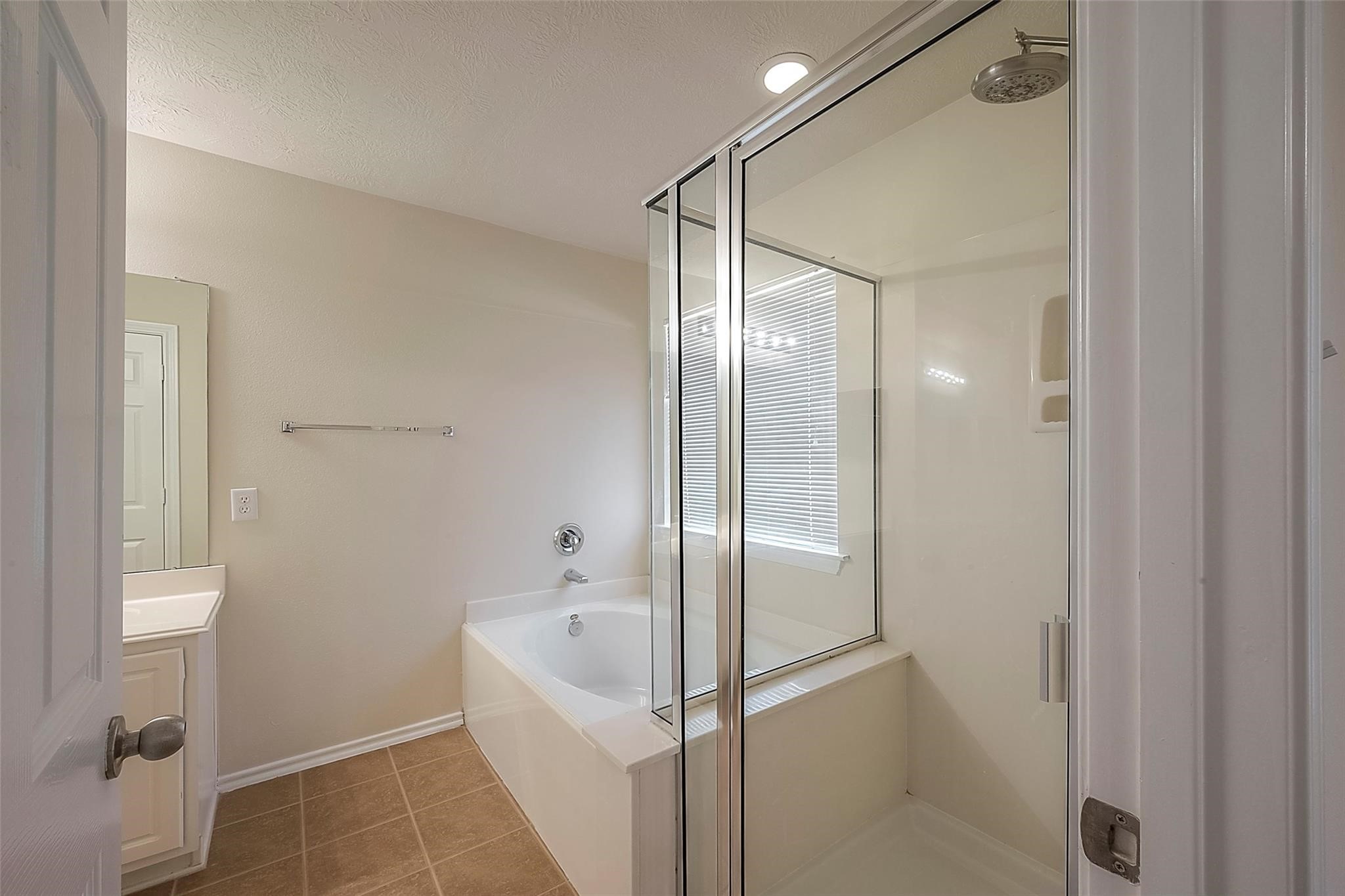 14330 Fairbuff Lane Houston, TX 77014 - Photo 23 of 35 a bathroom with a glass shower door and a bathtub