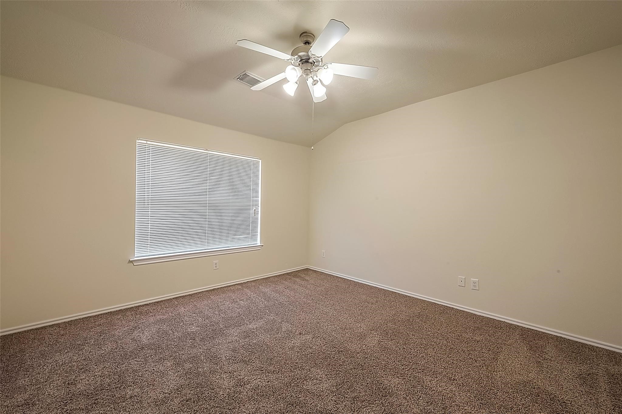 14330 Fairbuff Lane Houston, TX 77014 - Photo 27 of 35 an empty room with a chandelier fan and windows