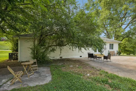 a backyard of a house with table and chairs